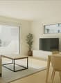 modern living room with sliding glass doors leading to a balcony, flat-screen TV, a potted plant, a wooden coffee table, a couch with cushions, dining table and chairs, and a white carpet