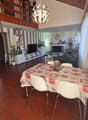 Dining room with dining table, chairs, fireplace, TV, shelves, plants, chandelier