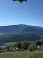 hillside with grass, trees, mountains, lake, town, construction site