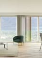 large sofa, large windows, coffee table, table with chairs, carpet, city view