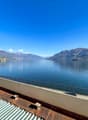 View from the terrace of the lake, mountains, and surrounding buildings.
