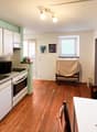 kitchen, wooden floor, white cabinets, sink, oven, window, lamps