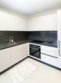 modern kitchen, white cabinets, black countertops, stainless steel sink, silver faucet, black oven, white tile flooring