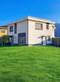 2 story house, white exterior, grey trim, large windows, garage, large grassy yard, mountains in background