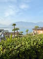 House with a view of the lake and mountains, solar panels on the roof, surrounded by greenery
