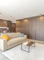 Modern living area with beige couch, white rug, coffee table, TV unit, dining table with chairs