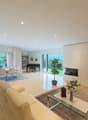 modern style, white tiled floor, dining area with table and chairs, living area with couch, carpet, table, shelves, piano, fireplace, tv, glass windows leading to terrace