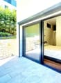 bedroom with bed, sliding glass door, wooden floor, stone wall, outdoor view