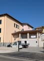 3 story building, beige exterior, multiple windows, parking lot, sign reading 'Vendesi'