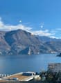 Mountainous region with a lake, buildings, and street lamps