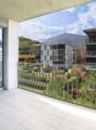 Balcony with railings, tiled floor, glass door, view of mountains and buildings
