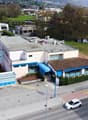 2-story building, parking in front of it, blue windows, brown roof