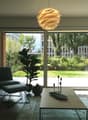 modern living room with sliding glass doors, large windows, modern furniture, plants, marble coffee table, rug, lamp