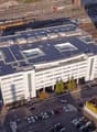 Office building, several stories, multiple solar panels on roof, large parking lot