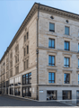Large office building, stone facade, multiple glass windows, modern architecture, street sign in front, urban setting