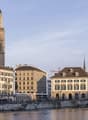 Modern building with medieval church in the background and a river in the foreground