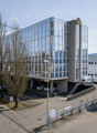 modern office building, glass facade, multiple floors, parking lot, multiple vehicles