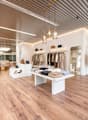 modern interior design, wooden floor, white walls, clothing racks, display tables, lamps