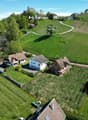 House in a vineyard, terraced houses, green lawn, trees, driveway, and parking area