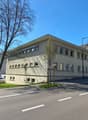 2 story beige building, 8 windows on each side, street in front