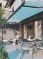 Outdoor patio with a table and chairs, a lounge chair, and a retractable awning.