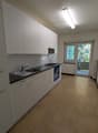 modern kitchen, white cabinets, black countertops, stainless steel sink, gas stove, oven, balcony