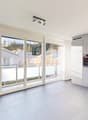 White tiles, white kitchen cabinets, oven, balcony with metal railings, sliding glass doors
