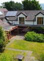2-story house, brown roof, glass windows, glass patio, small garden