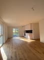 Empty room, wooden floor, white walls, windows, open to the kitchen