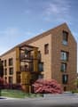 Modern apartment building with brick facade, wooden balconies, and a triangular roof design.