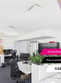 Modern and flexible office space with desks, computers, and office equipment. The space has a bright and open layout with white walls and ceilings. There is a sign indicating 'Zwischennutzung in Bulach' or 'Interim use in Bulach', suggesting this is a tem
