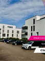 modern multi-storey building, outdoor parking, white exterior, multiple windows