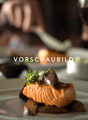 A plate of salmon with vegetables and a garnish of herbs