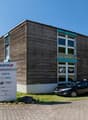 Commercial building, wood paneling, brick flooring, windows, cars parked in front