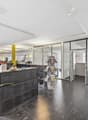 modern office interior with glass walls, yellow columns, reception desk, potted plant, glass doors, open layout, monitors, computers, magazines stand
