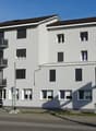 Modern building with 3 levels, glass windows, balconies, white paint, modern design, 3 balconies, black roof