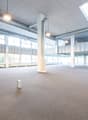Wide open space, large windows, hanging lamps, central column, balcony with railings, metal ducts on ceiling