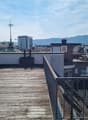 Wooden deck, metal railings, city view, mountains in the distance