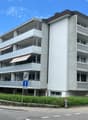 Multi-story apartment building, balconies, concrete exterior, modern design