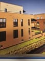 multi-storey building, beige exterior, glass windows, roof terrace, sea view