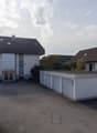 Two houses with garage in the middle. Wide empty space in front.