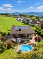 Generiertes Bild_ Chalet mit Pool vor Alpenpanorama