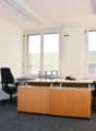 Empty office room, with three desks, two chairs, and cabinets