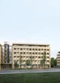 Modern multi-story hotel buildings with many windows, landscaped grounds with grass and trees, paved road in front, staircase entrance, glass wall, awnings over some windows, distant cyclists.