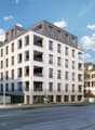 Residential apartment building, modern architecture, multiple floors, balconies, ground floor commercial spaces, and a parking area.