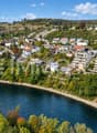 Flussstadt am grünen Hügelhang