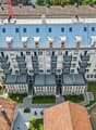 modern residential building, multiple balconies, large glass windows, landscaped area