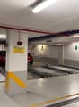 underground parking with parking spots, safety lights, and yellow and red warning stripes