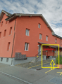 three-story apartment building, orange facade, gray base, gray roof, multiple windows, staircase entrance, mailboxes, small front garden