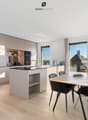 Licht, Raum und Design in Harmonie. Die hochwertige Küche mit Kochinsel verbindet sich mit dem Essbereich und wird zum Herzstück der Wohnung.